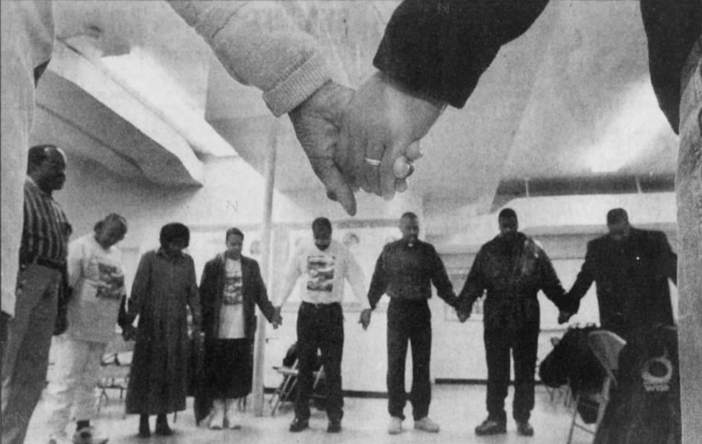 A group of people hold hands while standing in a circle.