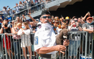 A bagpiper plays amid a mix of masked and unmasked fans as Helio Castroneves wins his fourth Indy 500, 2021