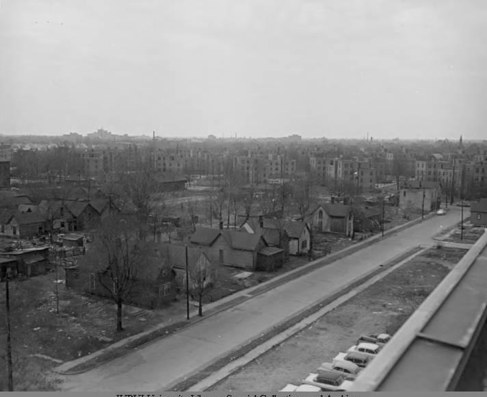 Aerial view of rows of houses along a road.