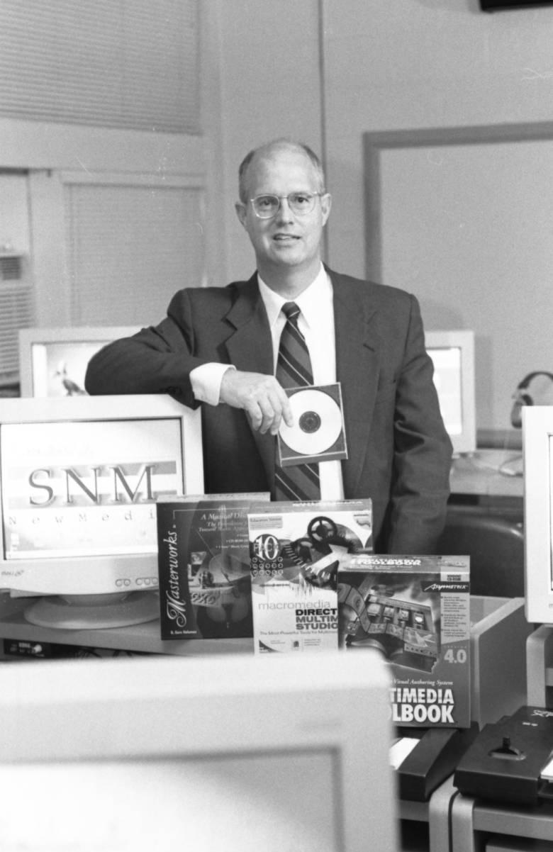A man stands holding a CD.