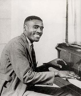 Leroy Carr sitting at a piano.