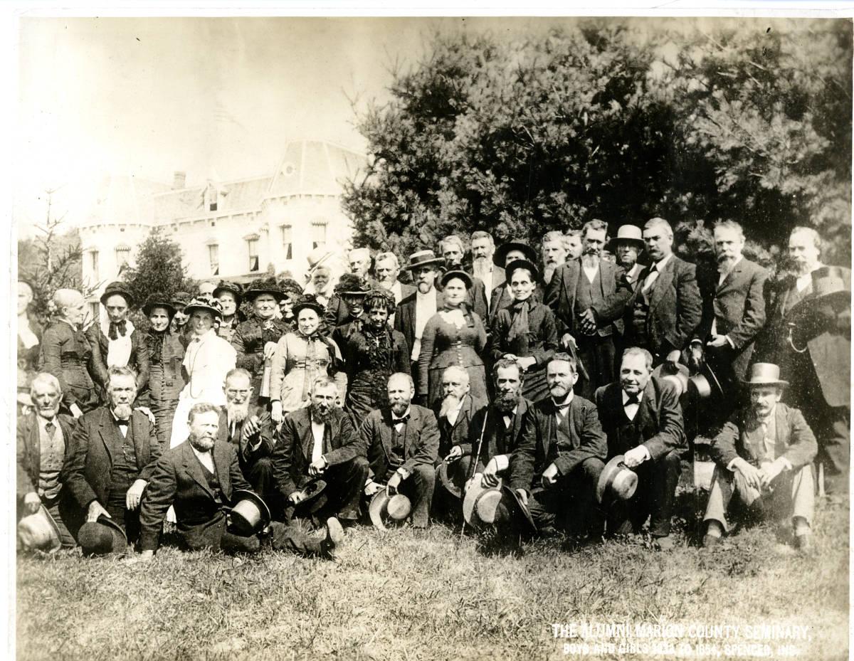 A group of people are gathered together outside for a photograph.