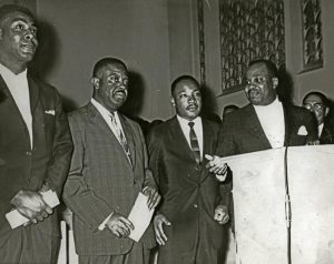 Reverend Kelly Miller Smith, Reverend Ralph Abernathy, Reverend Martin Luther King Jr., and Revered Andrew Brown addressing an NAACP meeting at Mount Zion Baptist Church, 1951
