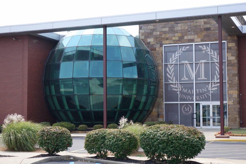 Front of Martin University building featuring a sphere of glass panels.