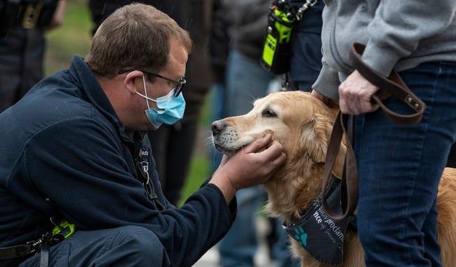 A man pets a dog.