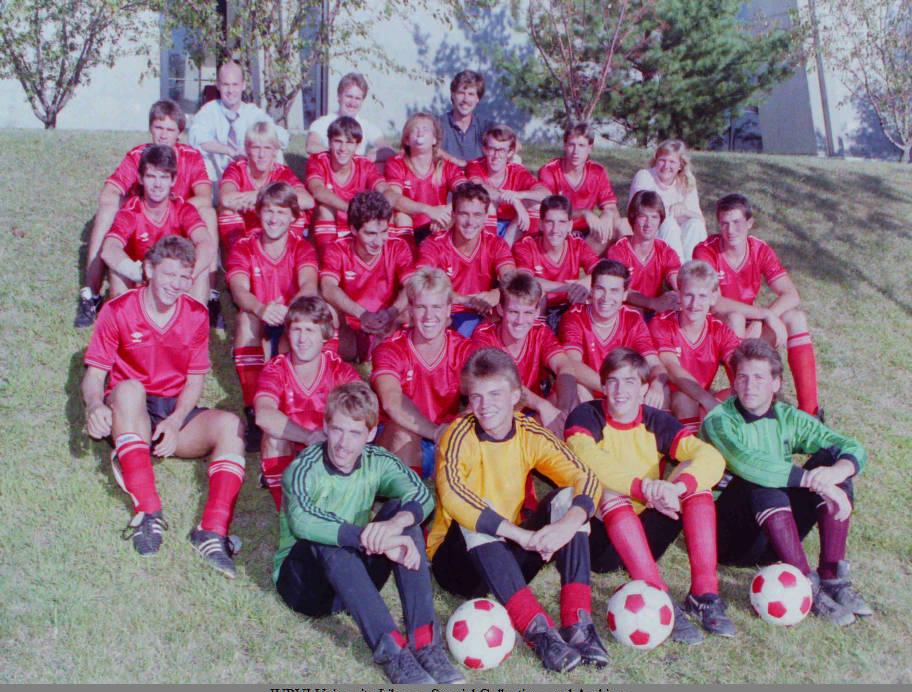 A group of young men in soccer uniforms pose together.