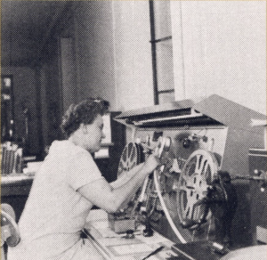 Librarian inspects 16mm film, ca. 1950s