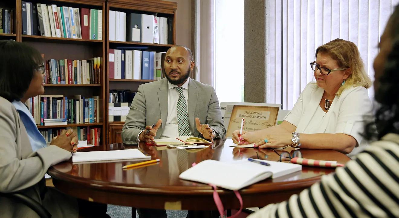 Several people sit together around a table.