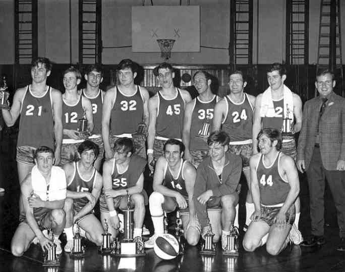 A group of young men in basketball uniforms pose together.