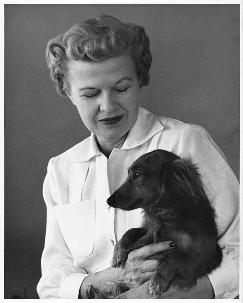 Nina Mason Pulliam holds a small dog. 