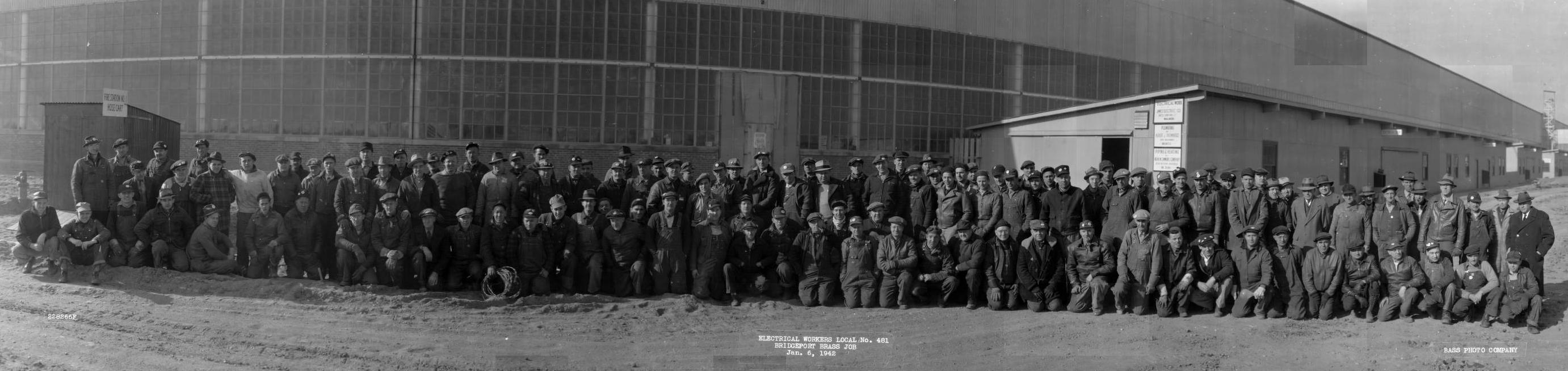 A group photo of electrical workers in front of a building.