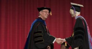 Chancellor Charles Bantz congratulates graduate at commencement, 2014