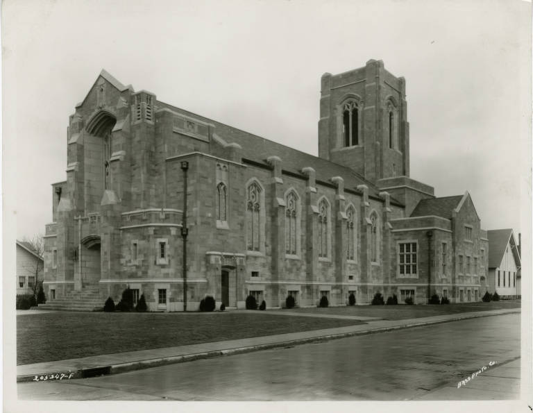 Exterior view of a large gothic-style limestone church building. 