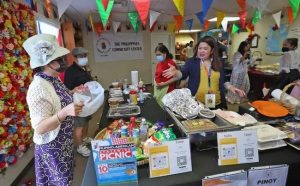 Cristina Miranda, right, works the Philippines Cultural Community Center booth during the Filipino Bazaar, 2021
