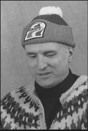 Headshot of a man wearing a knitted cap.
