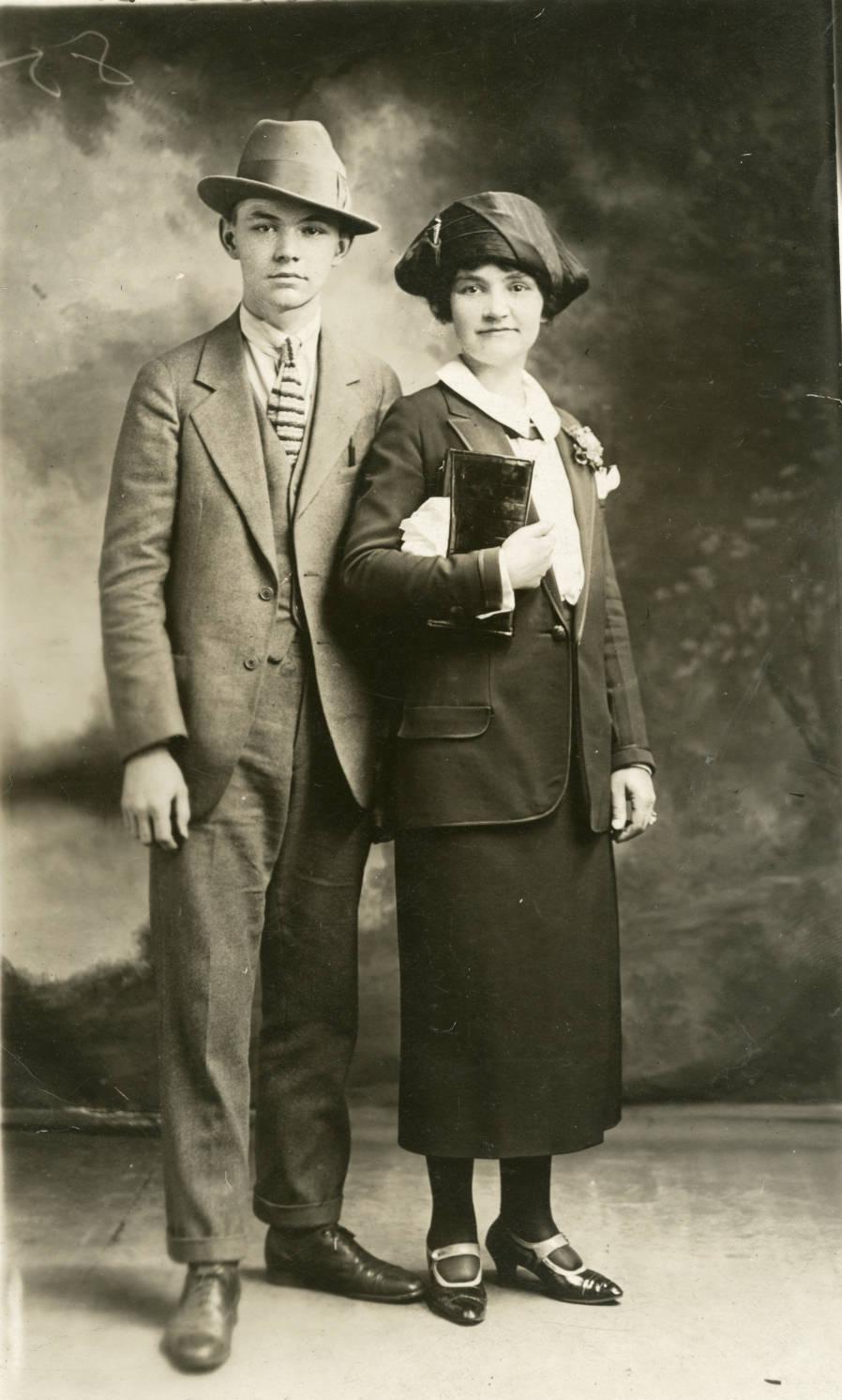 A young man stands next to his mother in a photoshoot image.