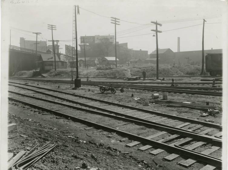 Railroad tracks with several small buildings in the background.