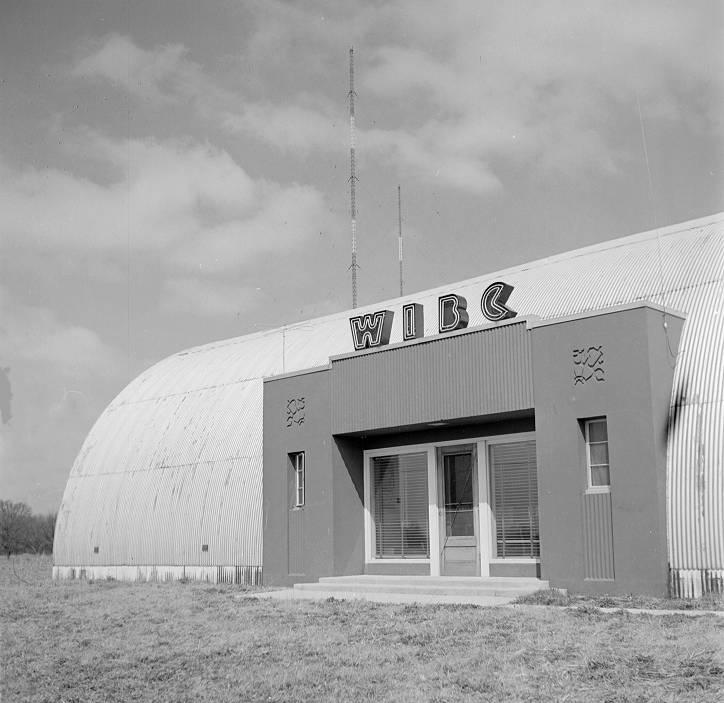 The building is a white Nissen hut with a rectangular entrance built into one side with the letters WIBC over it.
