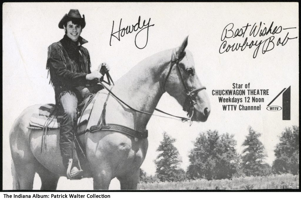 A man dressed as a cowboy sits o a horse. 