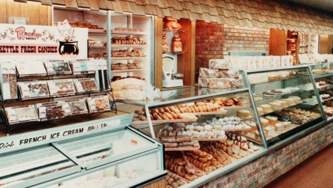 A bakery counter with a glass case filled with pastries. 