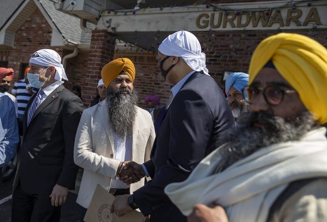 Rep. Andre Carson is shaking the hand of a Sikh man. 