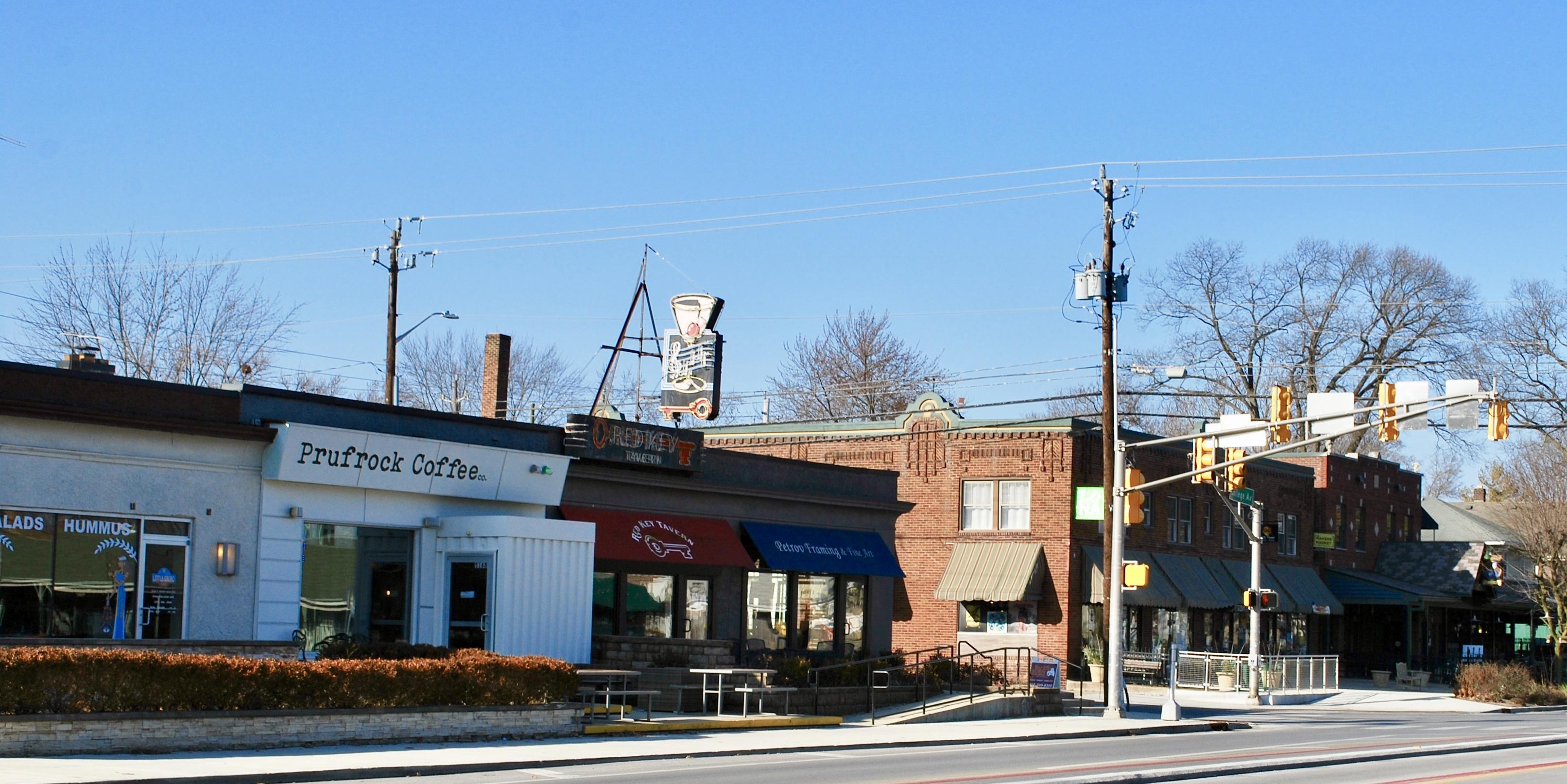 A row of connected businesses including a coffee shop, tavern, and framing store. 
