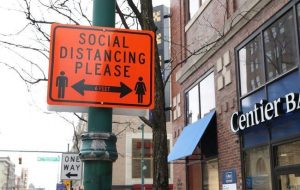 Street signs encourage social distancing as a precaution of the coronavirus pandemic in downtown Indianapolis, 2020