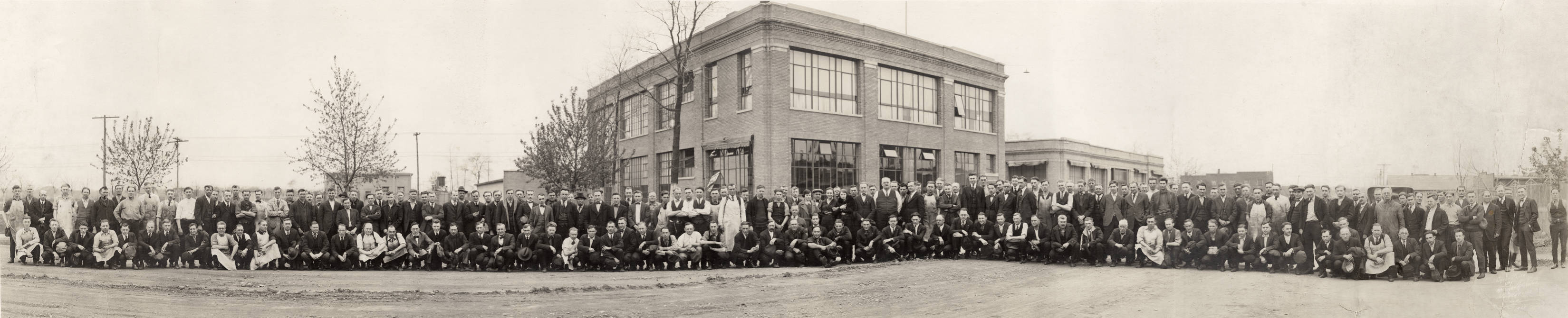 A large group of people pose for a photograph outside of a building.