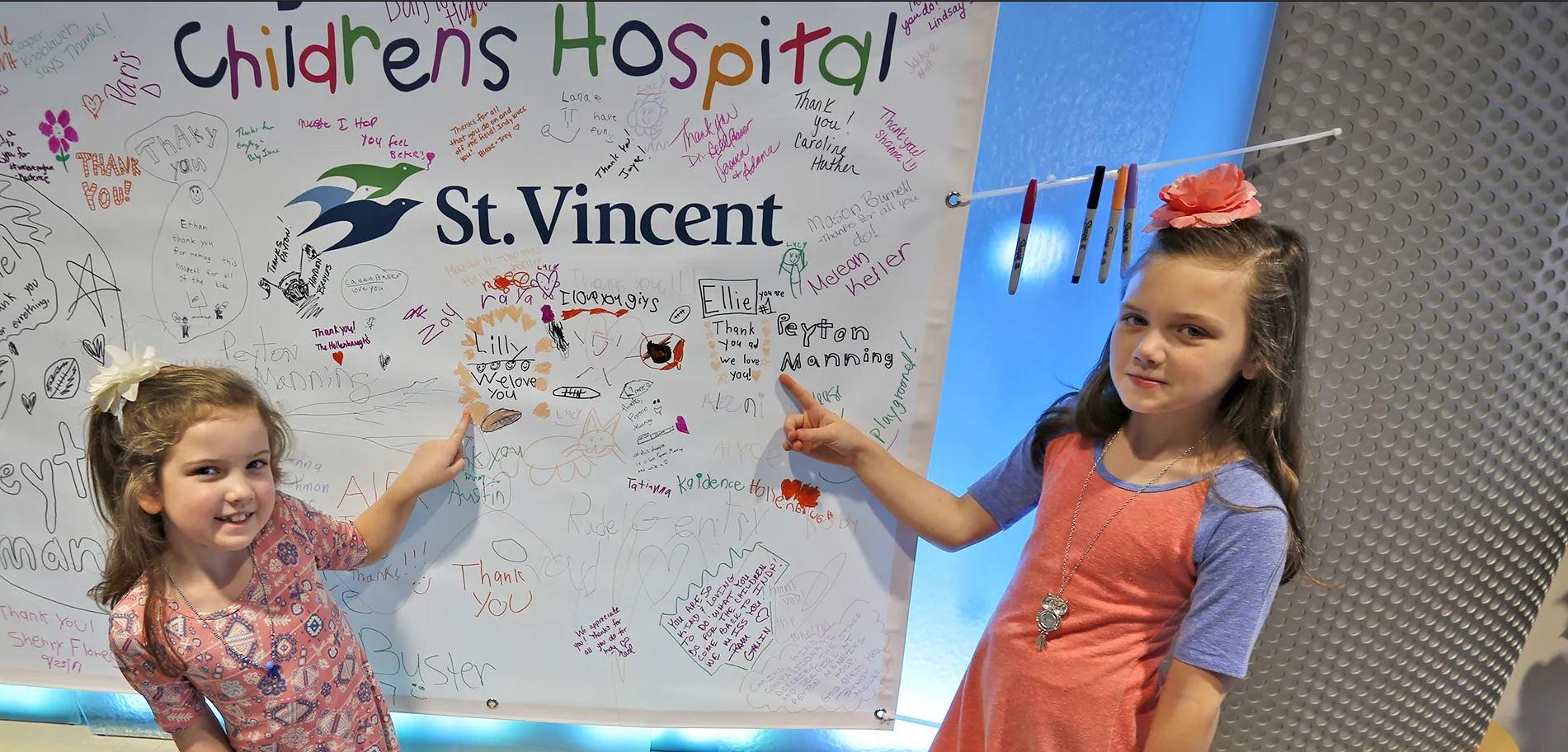 Peyton Manning Children's Hospital patients pose before board honoring its namesake, the former NFL Colts quarterback.