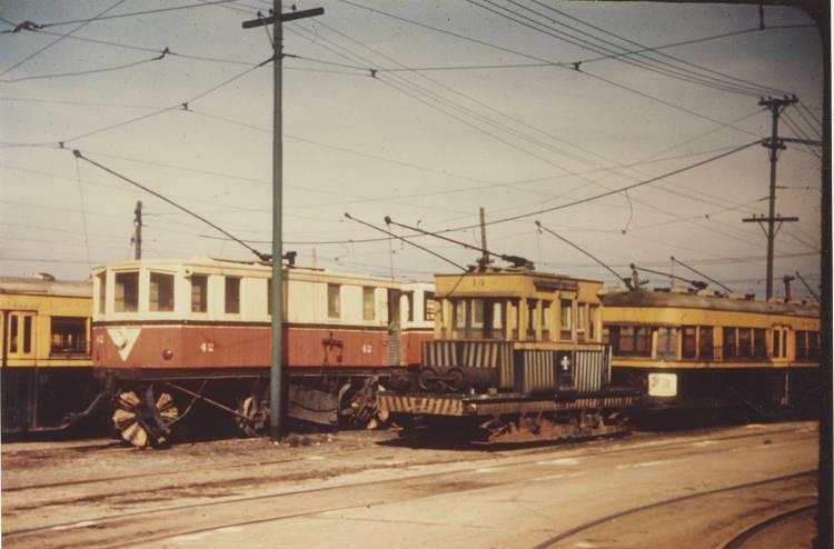 Several streetcars are parked on tracks.