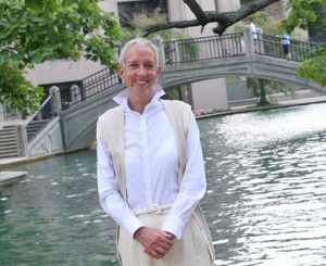 Portrait of Tamara Zahn standing. The backround is a canal and walking bridge.