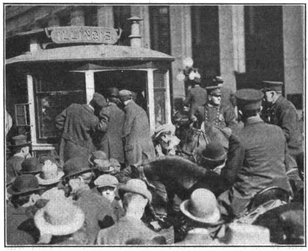 A group of people surround a trolley car. A police officer sits on a horse. 