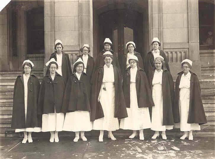 Nurses stand together outside of a building.