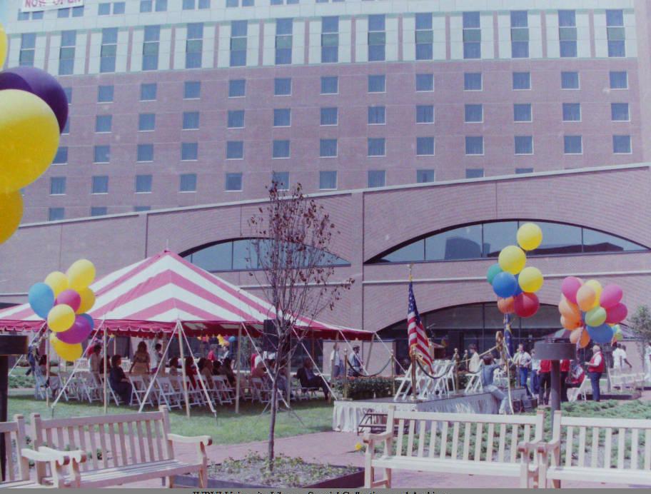 Tents and balloons decorate the front lawn of a hotel building.