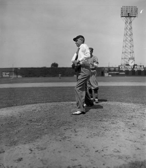 Two men stand on a pitcher's mound in a baseball field.