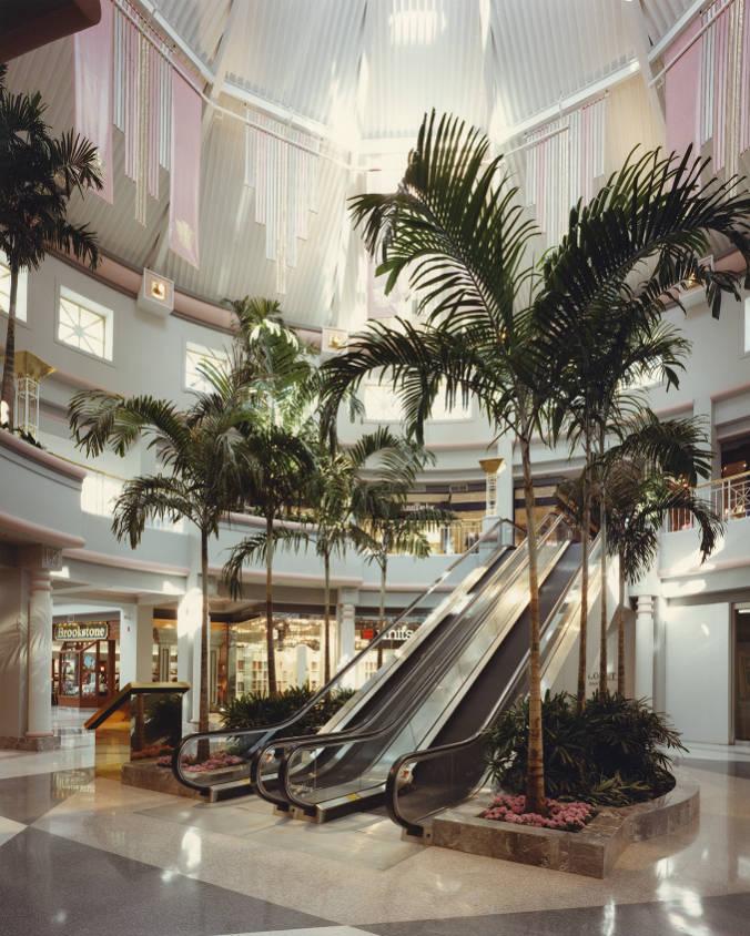 Interior of a mall showing an escalator.
