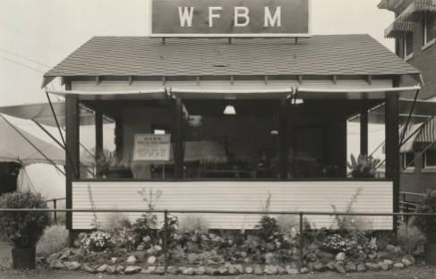 A small building with a sign on the roof that reads W F B M.