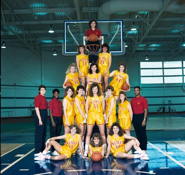 A group of women in basketball uniforms pose together.