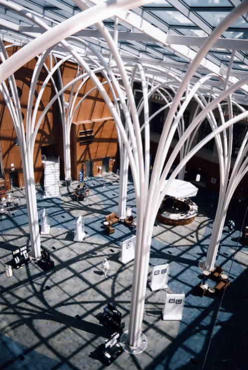 A view looking into the atrium at the Central Branch of the Indianapolis Public Library. The atrium features large arched columns, a circular reference desk, and several books on display. 
