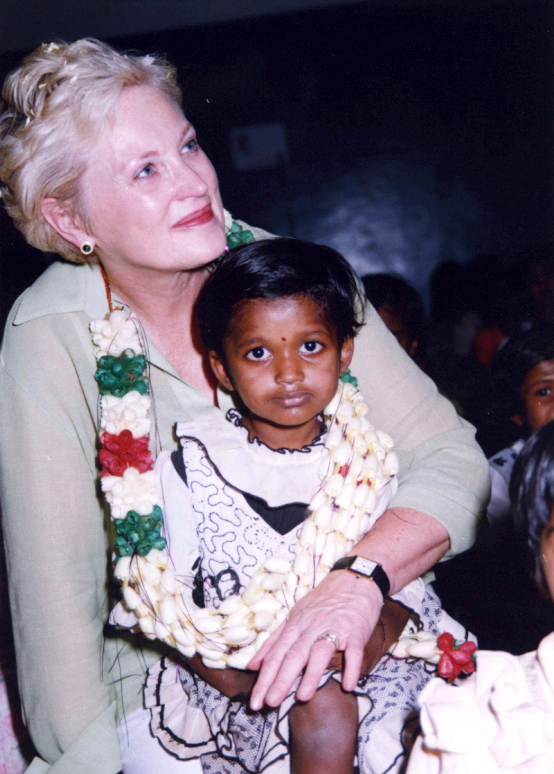 A woman is seated and holding a young child.