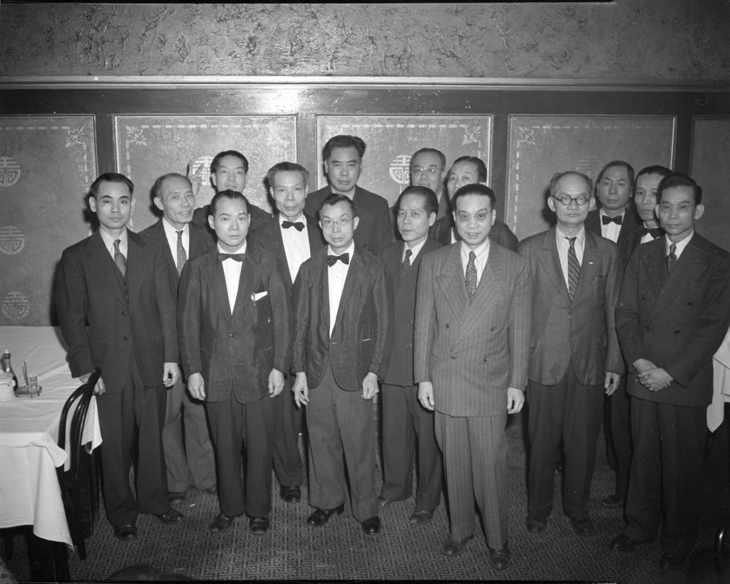 A group of Asian men stand together. 