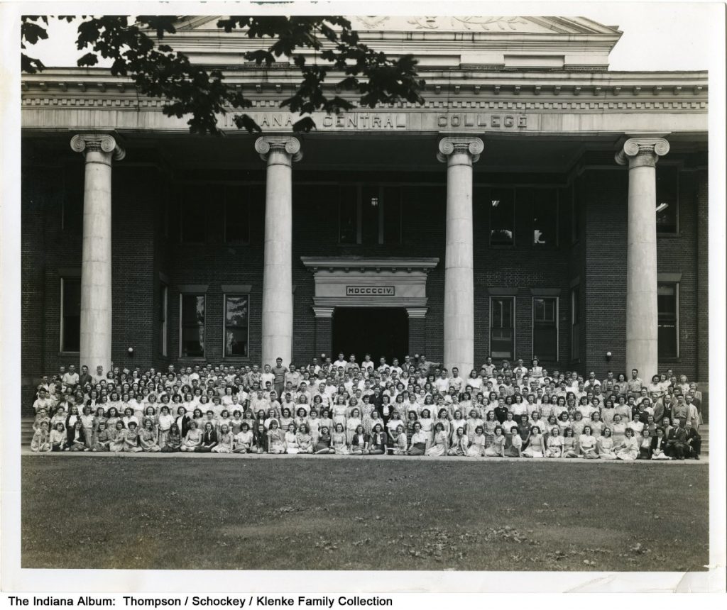 A large group of students pose in front of the Indiana Central College.