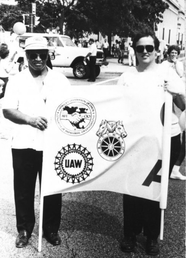 Columbus Mabry and Sue Leats carry the banner of the United Auto Workers Union.