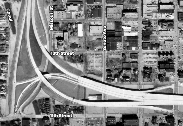 Aerial view of several city blocks with a large interstate running through them. The street names are identified. 