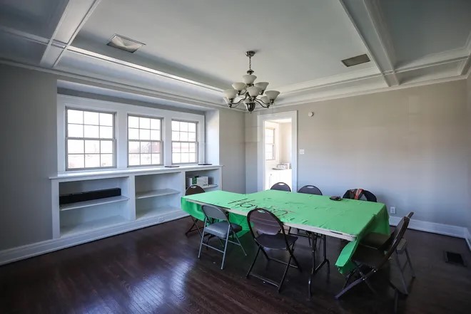 A dining room with a rectangular table in the center. A banner that says "haven" covers the table. 