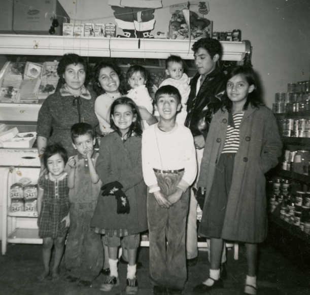 A family stands together in a grocery store.