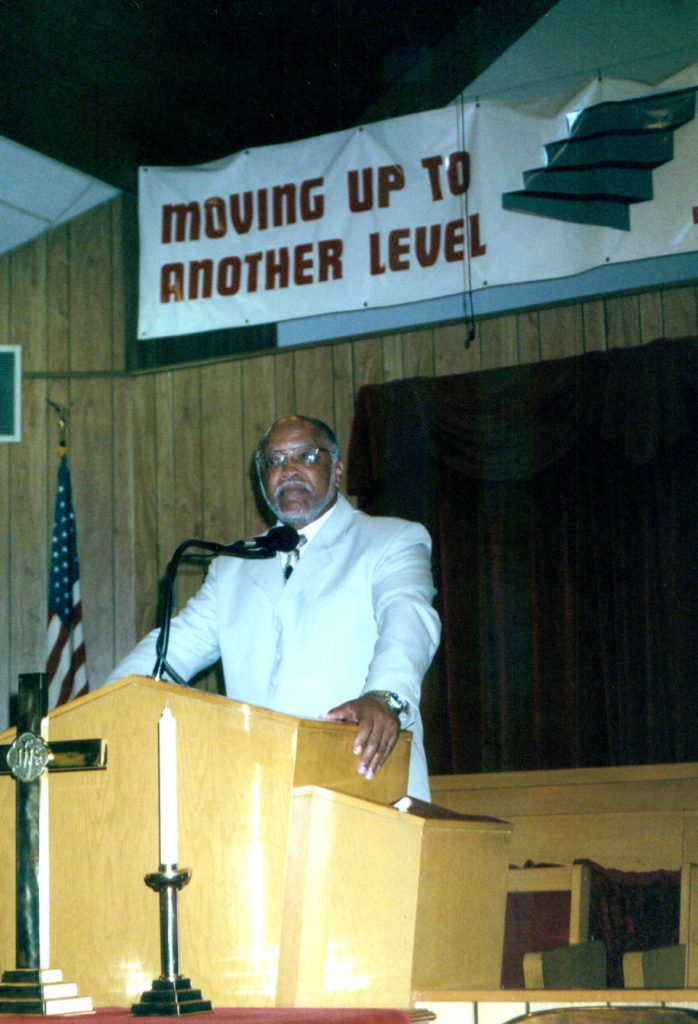 A preacher stands behind a pulpit. 