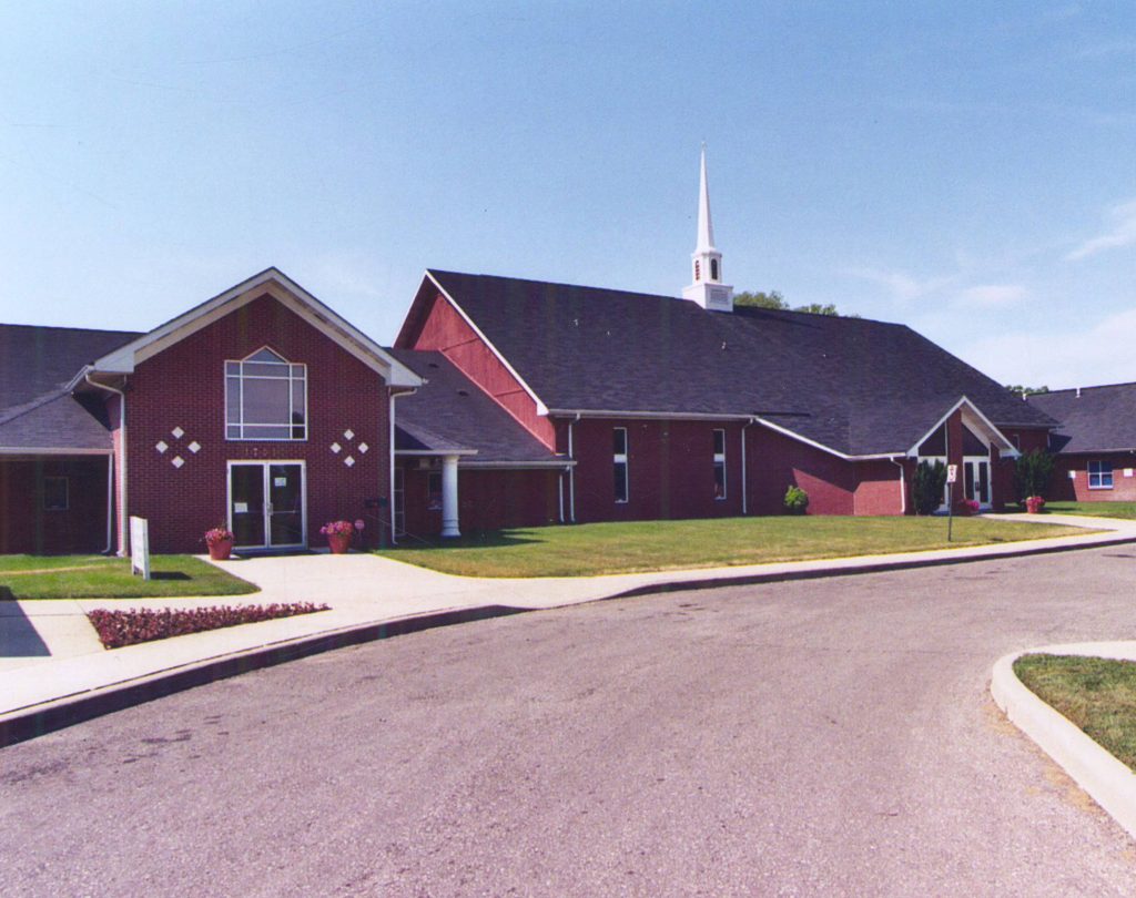 Exterior view of a sprawling red brick church building.