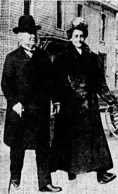 A woman and a man walk next to each other on the street.