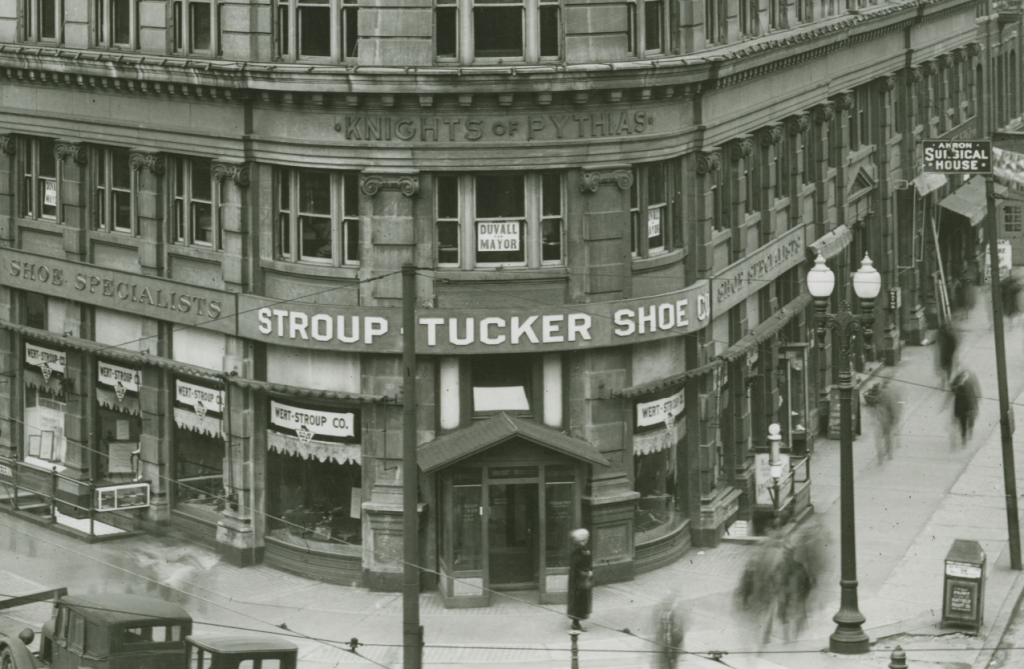 Close up view of the front of a large, multistoried building. Words affixed to the building read "Knights of Pythias."